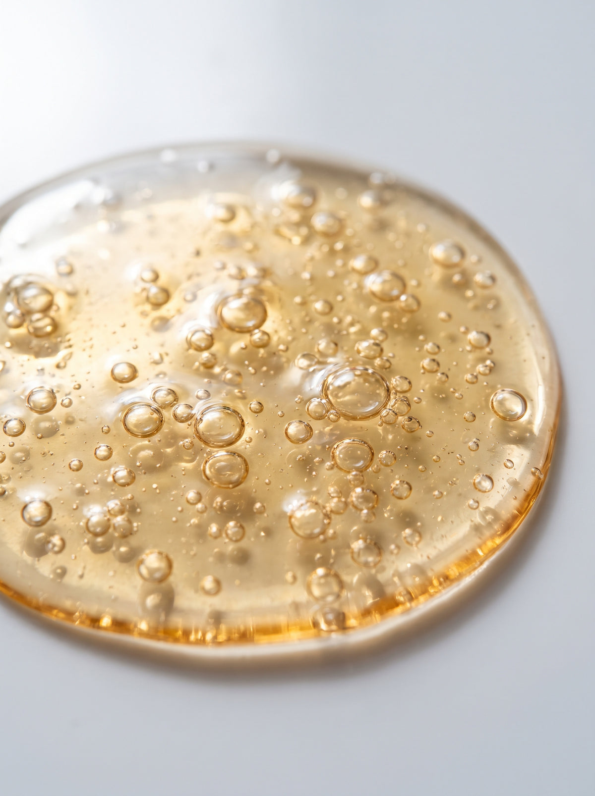 SILNT Makeup Remover golden bi-phasic swatch with suspended droplets on a light grey background
