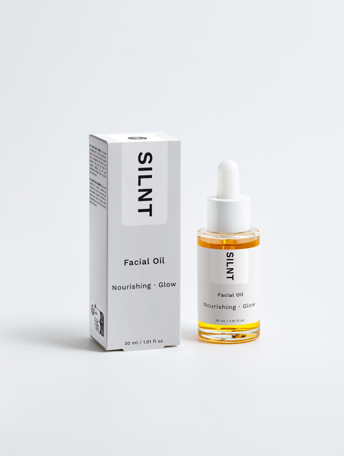SILNT Facial Oil bottle standing beside its carton on a light grey background