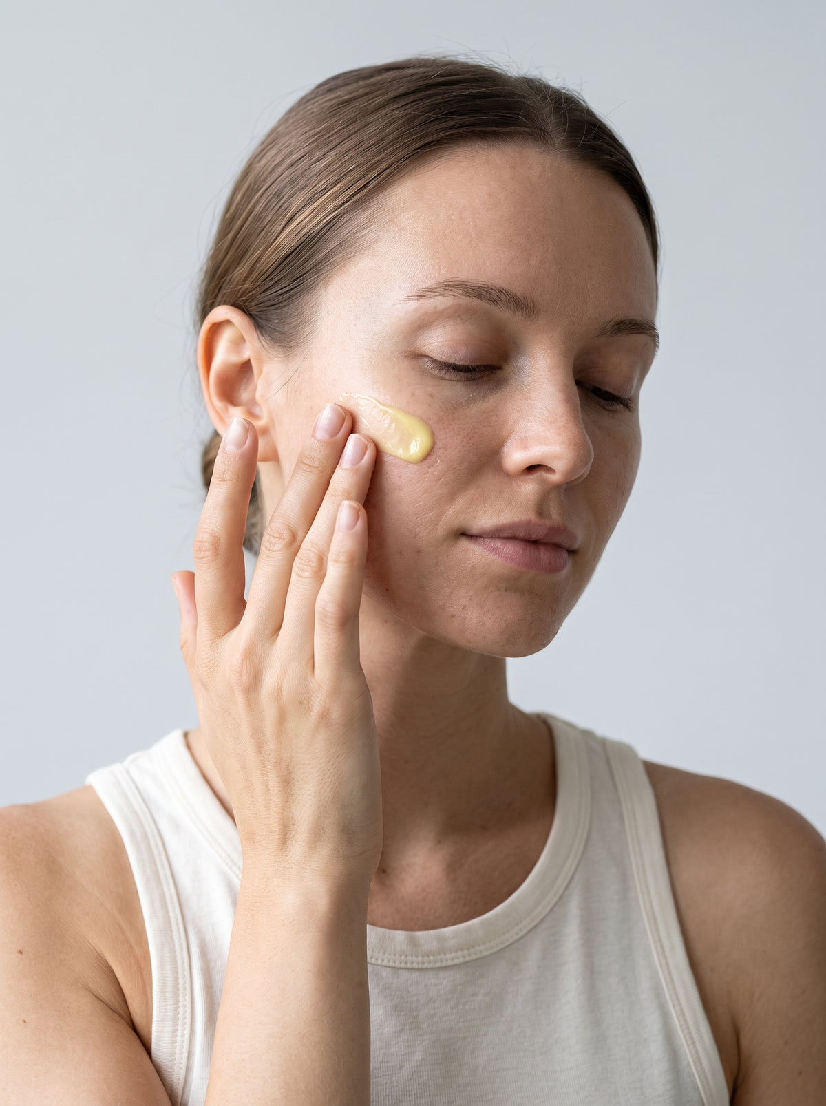 Woman applying SILNT Vitamin C Serum to her cheek