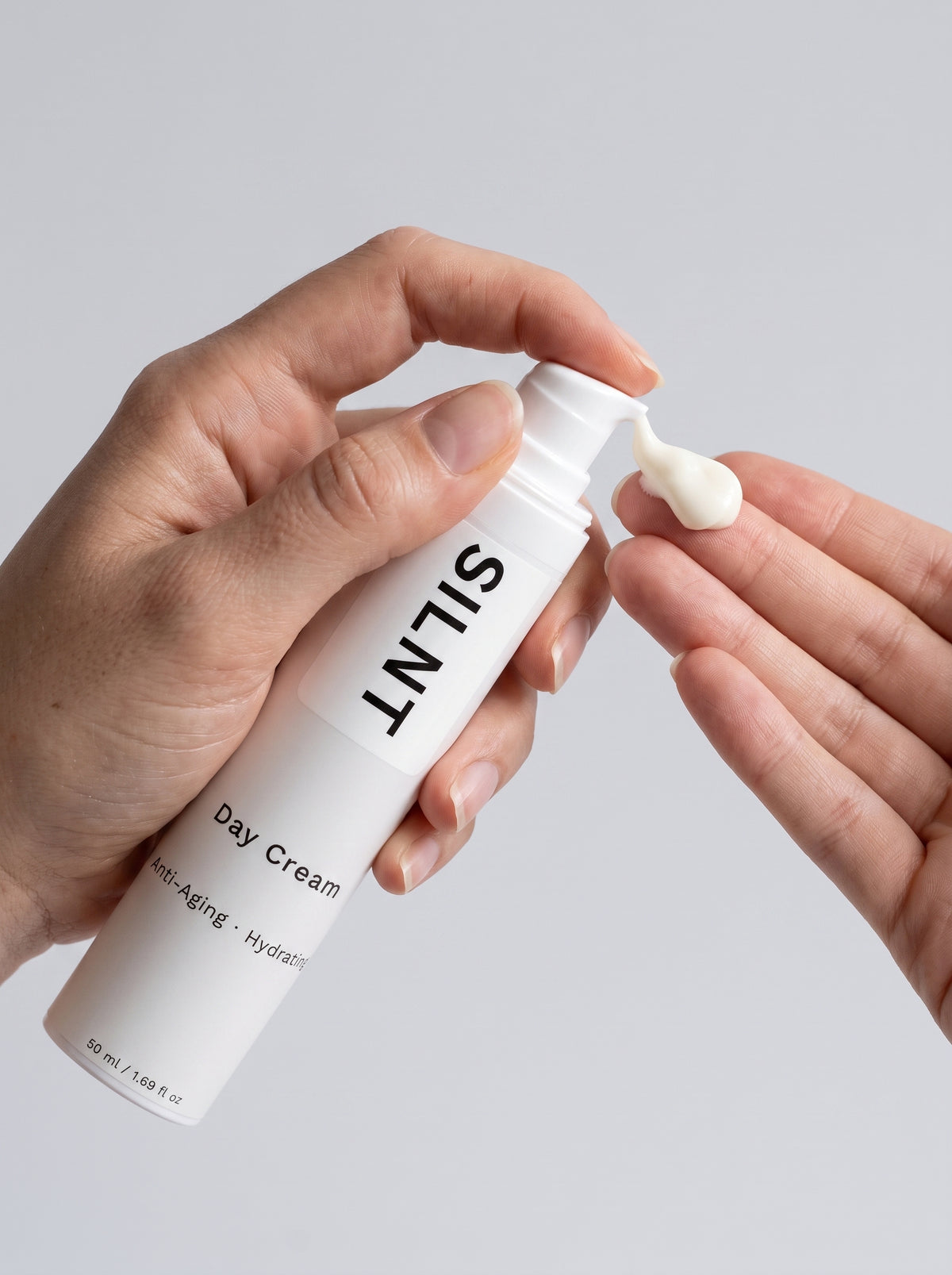 SILNT Day Cream bottle held in both hands with the Anti-Aging · Hydrating label facing forward