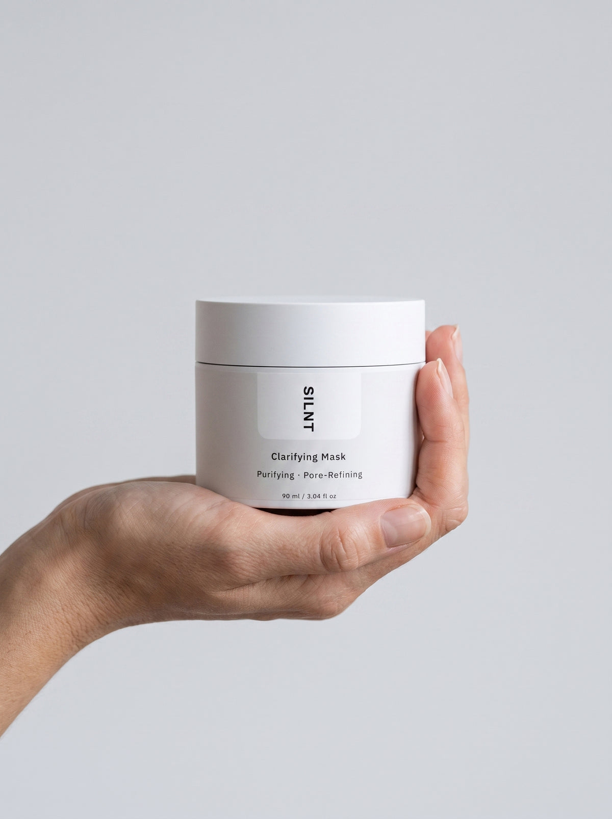 SILNT Clarifying Mask jar held upright in one hand, showing its 90 ml size, light grey background