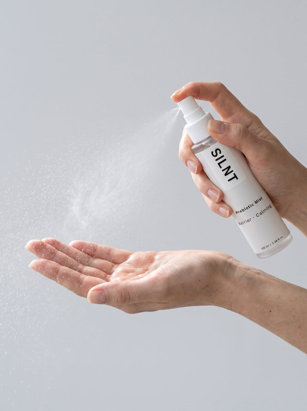 Hand spraying SILNT Prebiotic Mist into an open palm