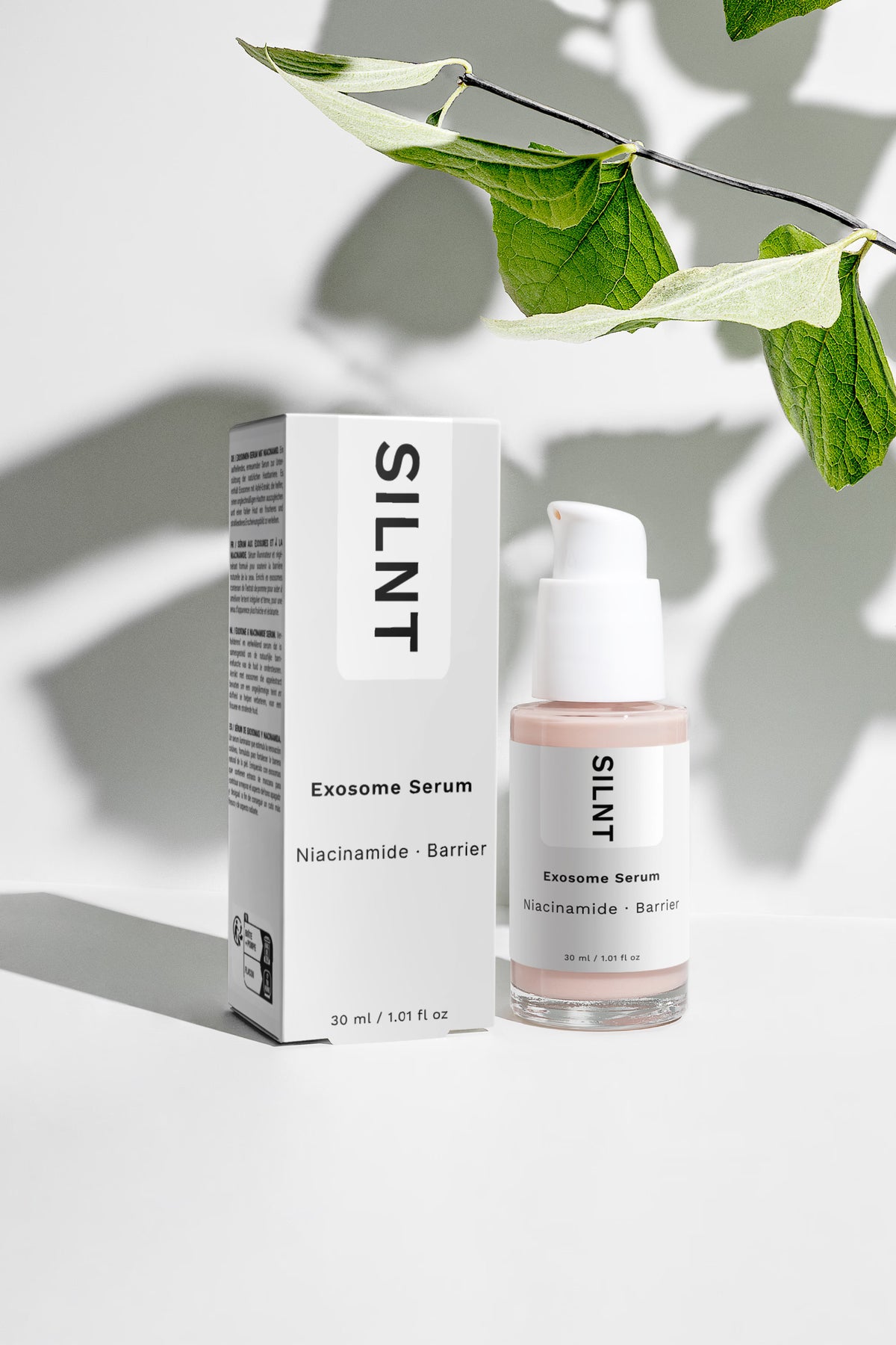 SILNT Exosome Serum carton box and bottle beside a leaf casting soft shadows