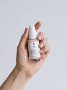 Hand holding the SILNT Exosome Serum bottle upright