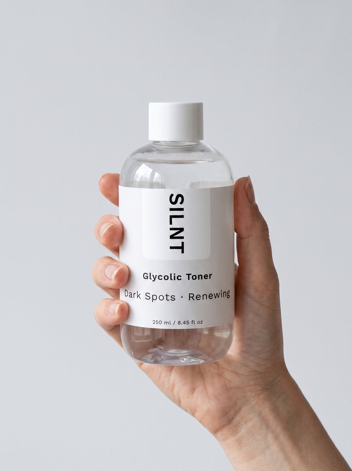 Hand holding the SILNT Glycolic Toner bottle upright