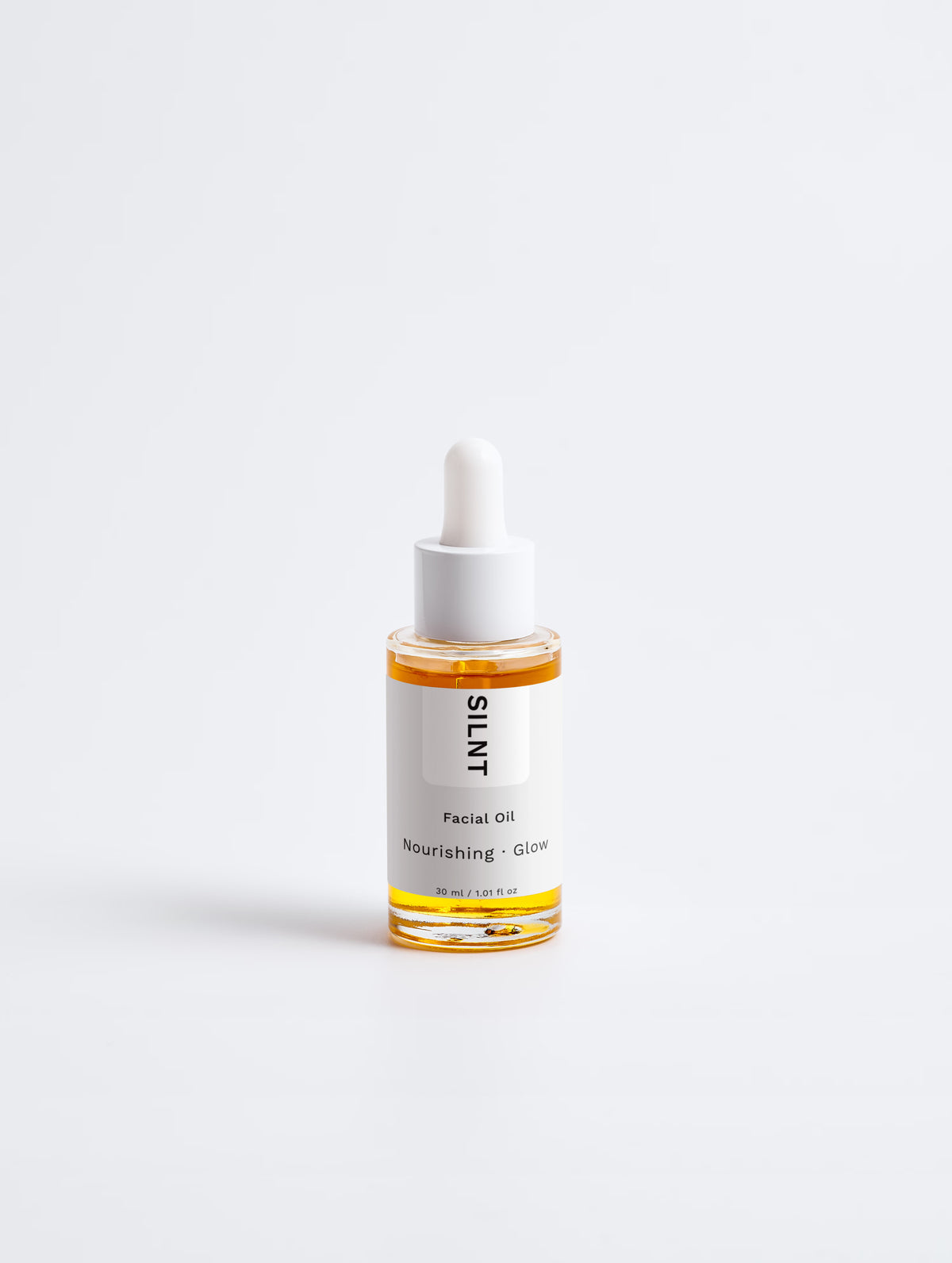SILNT Facial Oil glass dropper bottle with amber oil on a light grey background