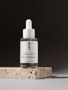 SILNT Exfoliating Concentrate on travertine against a dark background