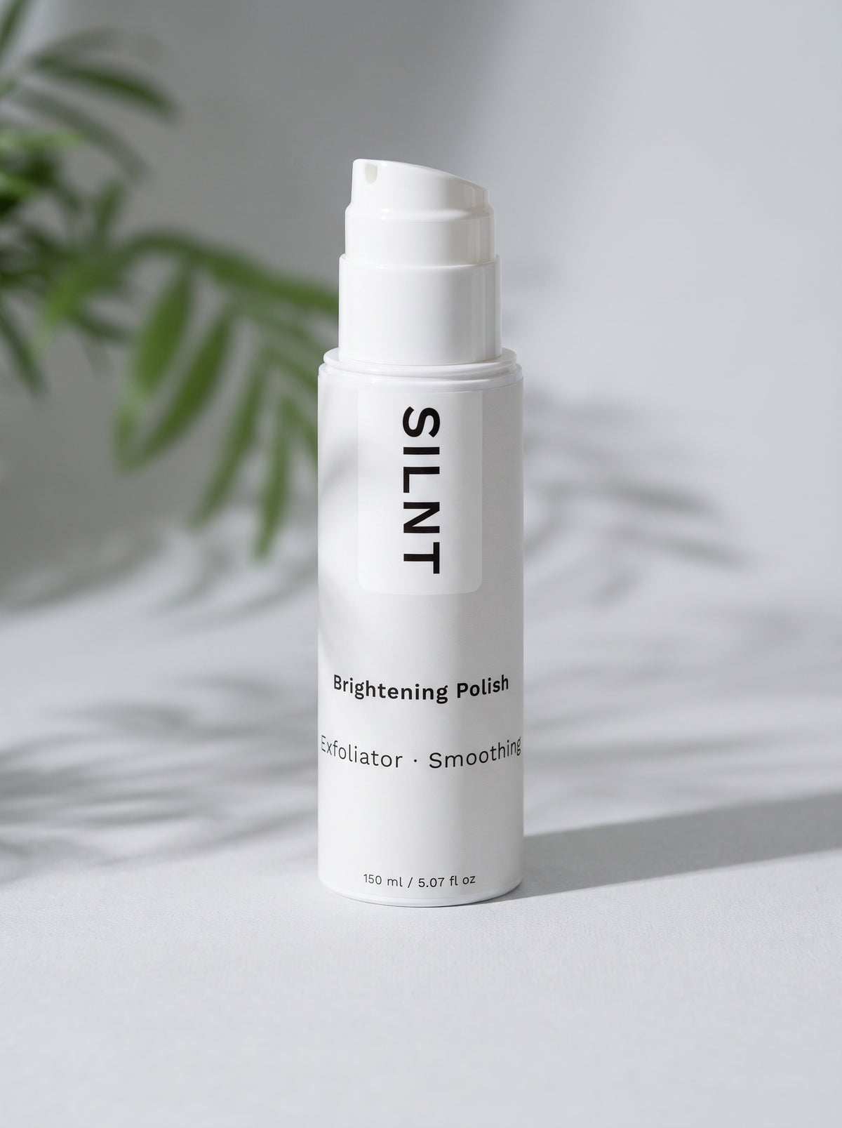 SILNT Brightening Polish bottle resting beside soft tropical leaf shadows