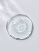 SILNT Exfoliating Concentrate clear gel swatch in a glass dish on a light grey background