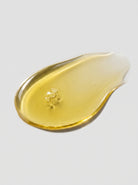 SILNT Bakuchiol Serum golden oil swatch with a glossy finish on a light grey background