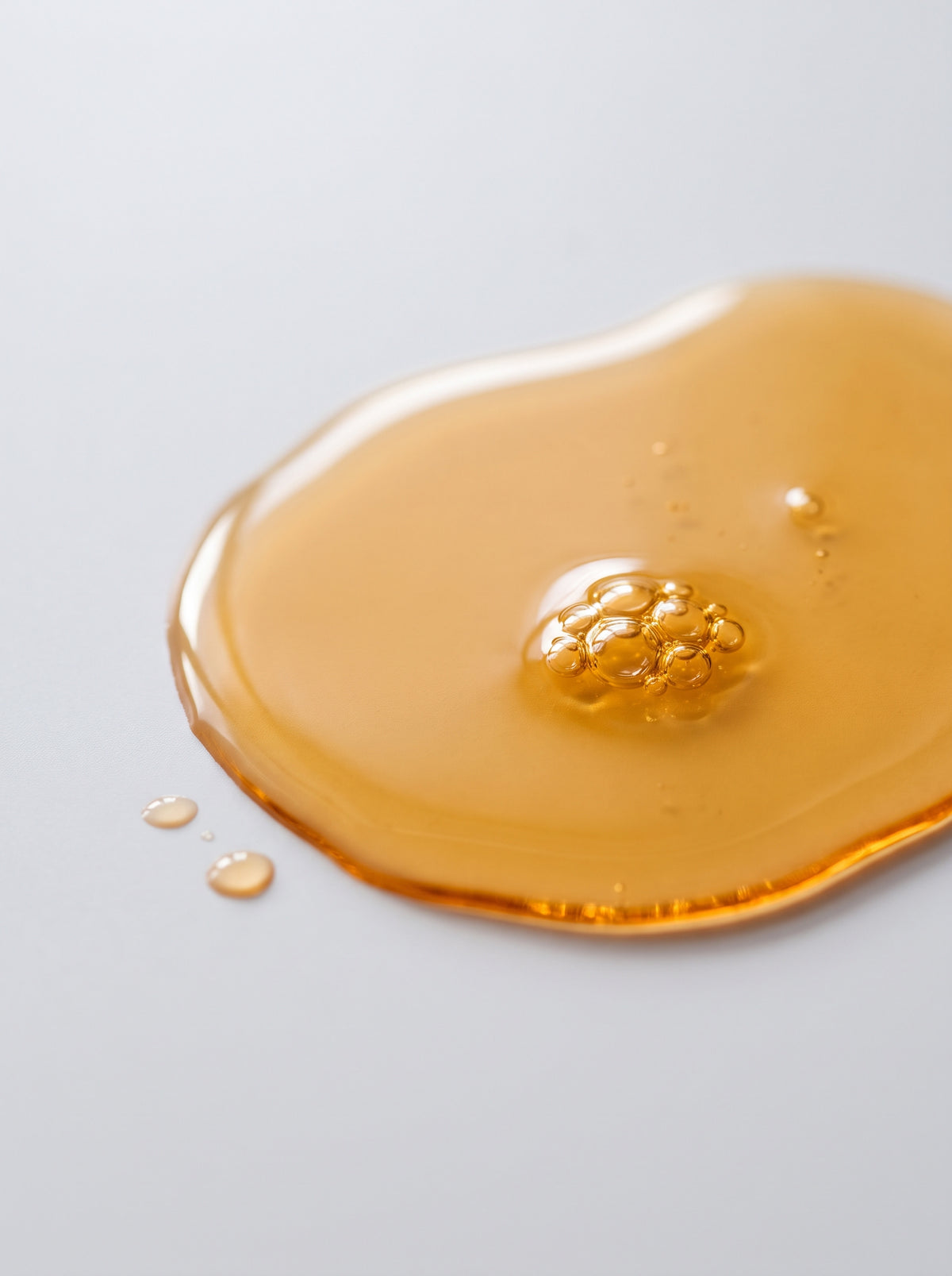 SILNT Facial Oil amber oil swatch with a glossy finish on a light grey background