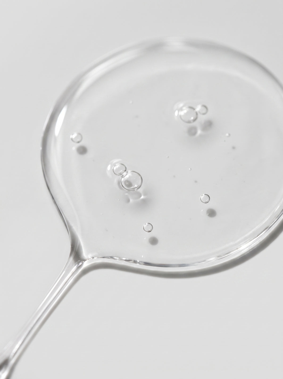 Clear gel serum droplet of SILNT Prebiotic Serum showing tiny bubbles and its transparent texture