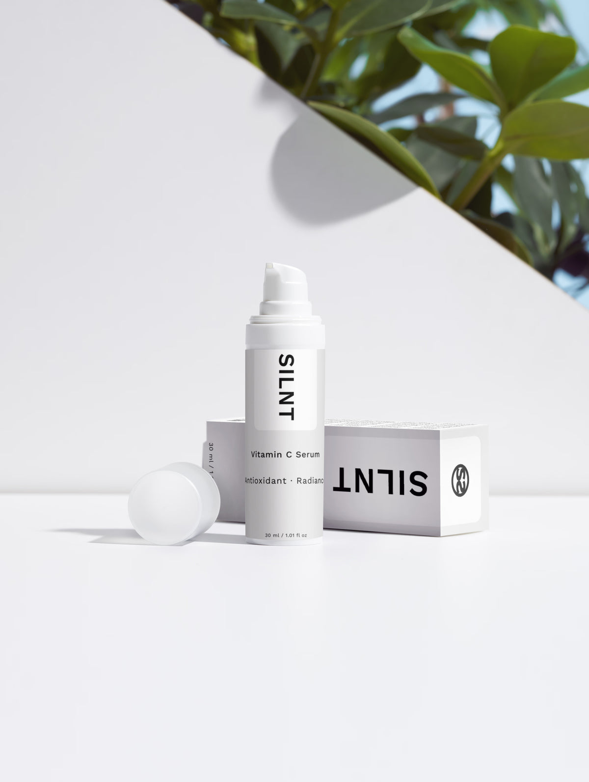 SILNT Vitamin C Serum bottle in natural light with soft plant shadows