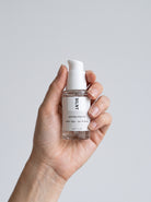 Hand holding the SILNT Caffeine Booster pump bottle upright