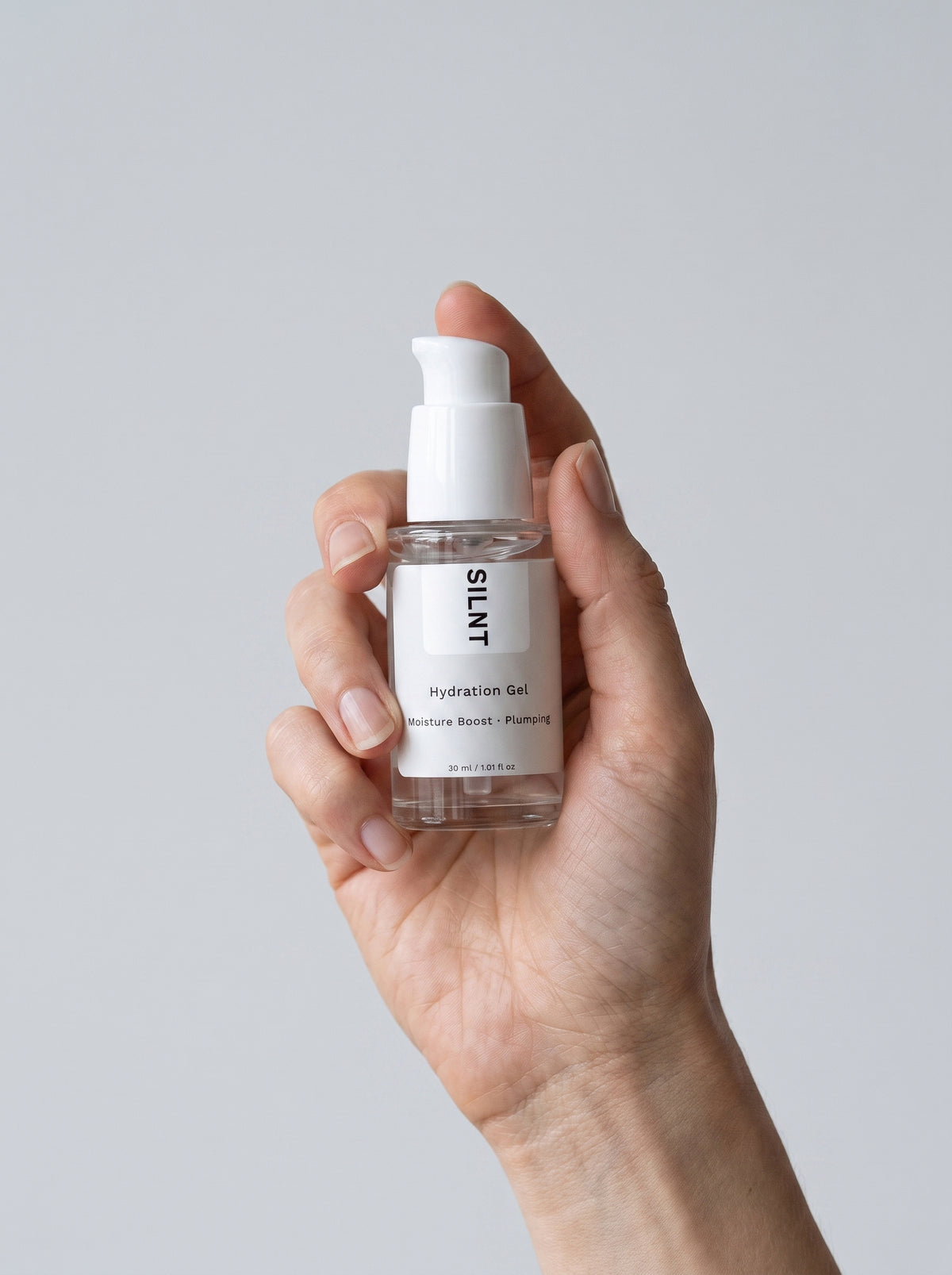 SILNT Hydration Gel bottle held upright in one hand against a light grey background