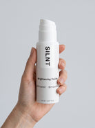 Hand holding a SILNT Brightening Polish bottle