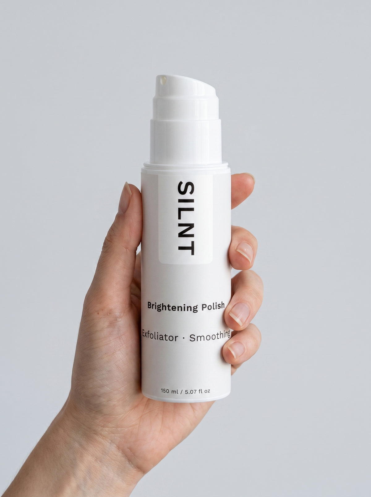 Hand holding a SILNT Brightening Polish bottle