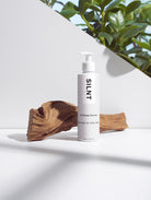 SILNT Clarifying Cleanser bottle beside its carton on a light grey background