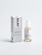 SILNT Brightening Serum bottle standing beside its white carton on a light grey background