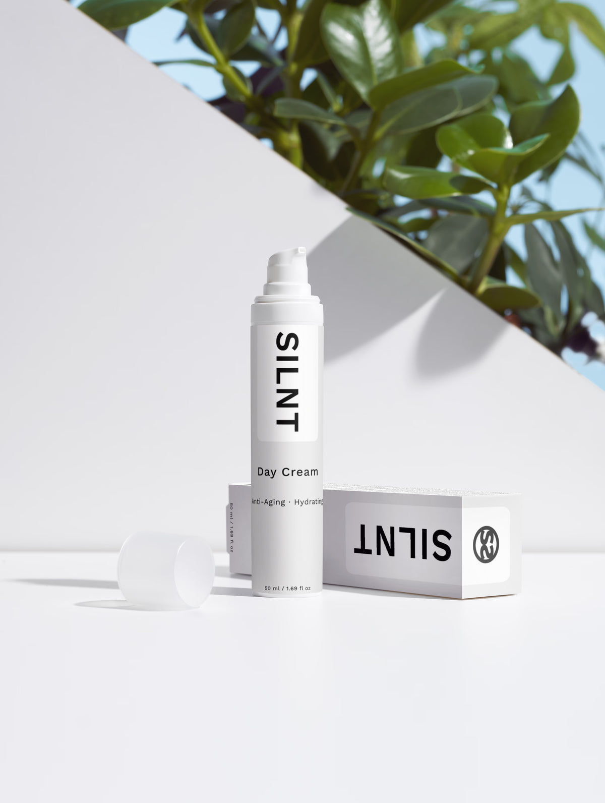 SILNT Day Cream 50 ml bottle beside its carton with soft leaf shadows